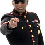 Sänger Captain Jack in schwarzer Offizierskleidung mit einer roten Mütze, er zeigt mit dem Finger in die Kamera