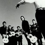 Band Chico and the gypsies stehen an einem Strand, das Bild ist schwarz-weiß und jeder hat eine Gitarre in der Hand