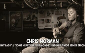 Sänger Chris Norman spielt Gitarre an eine Wand angelehnt