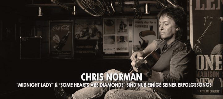 Sänger Chris Norman spielt Gitarre an eine Wand angelehnt