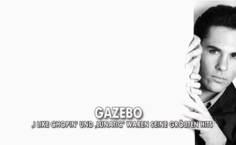 Sänger Gazebo in schwarz-weiß mit einem dunklen Anzug, er blickt hinter einer Wand hervor