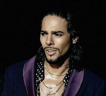 Joaquin Cortes in einem lila Sakko und einem gepunkteten Hemd