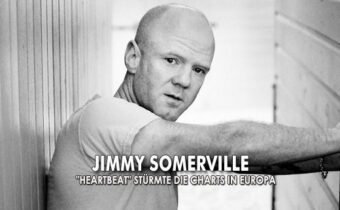 Jimmy Somerville in schwarz-weiß lehnt an eine Tür