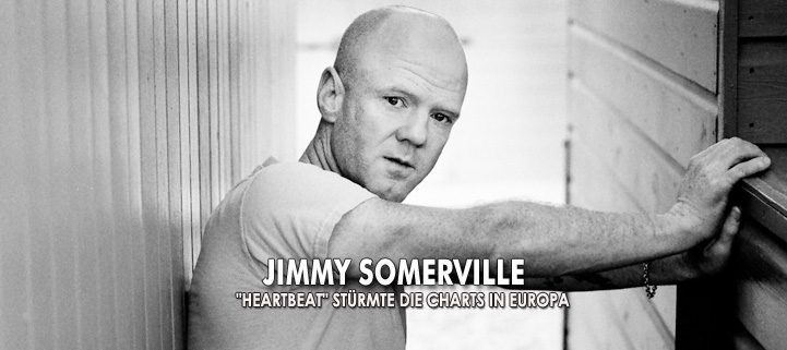 Jimmy Somerville in schwarz-weiß lehnt an eine Tür