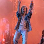 Sänger Wolfgang Petry auf der Bühne mit den Händen in der Luft, im Hintergrund die Bühne und Roter Nebel