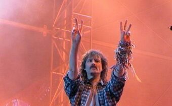 Sänger Wolfgang Petry auf der Bühne mit den Händen in der Luft, im Hintergrund die Bühne und Roter Nebel